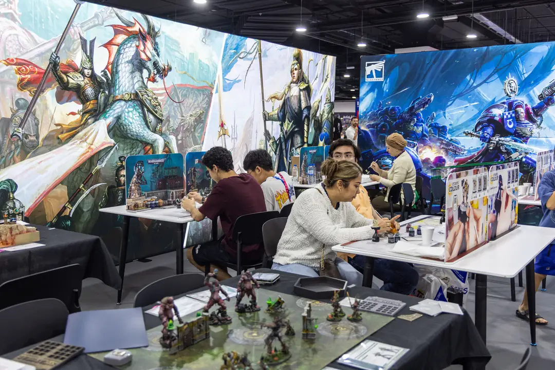 Visitors painting miniatures at a hands-on workshop table at tabletop.me